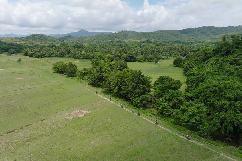 A rural landscape with fields, trees, and distant hills. 3