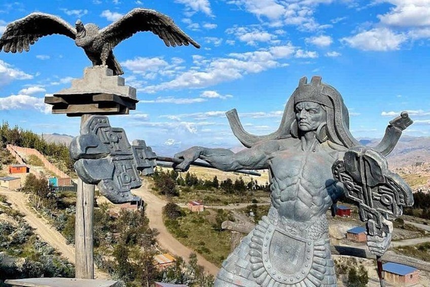 En stor staty som föreställer en figur med utsträckta armar, en fågel på toppen och en sockel med intrikata mönster. 2