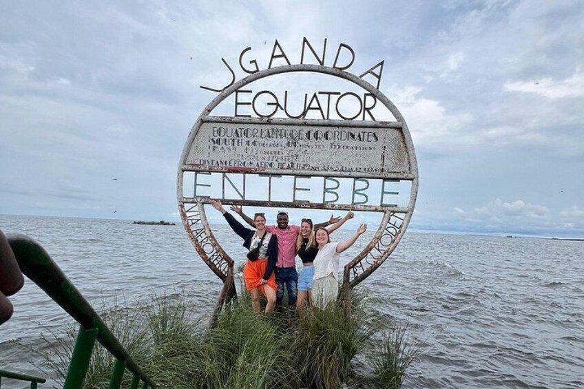 Un letrero con la inscripción 'J'GAIDA EQUATOR' y 'ENTREBEE', rodeado de agua. 4