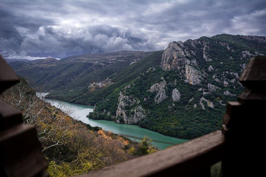 Un paisaje montañoso con un río, acantilados rocosos y un cielo nublado. 1