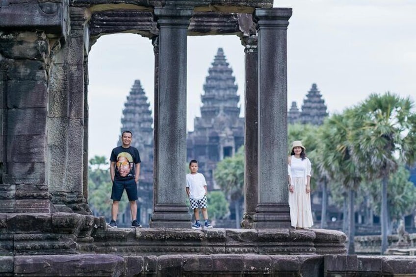 A temple with large stone columns and a person standing in front. 1