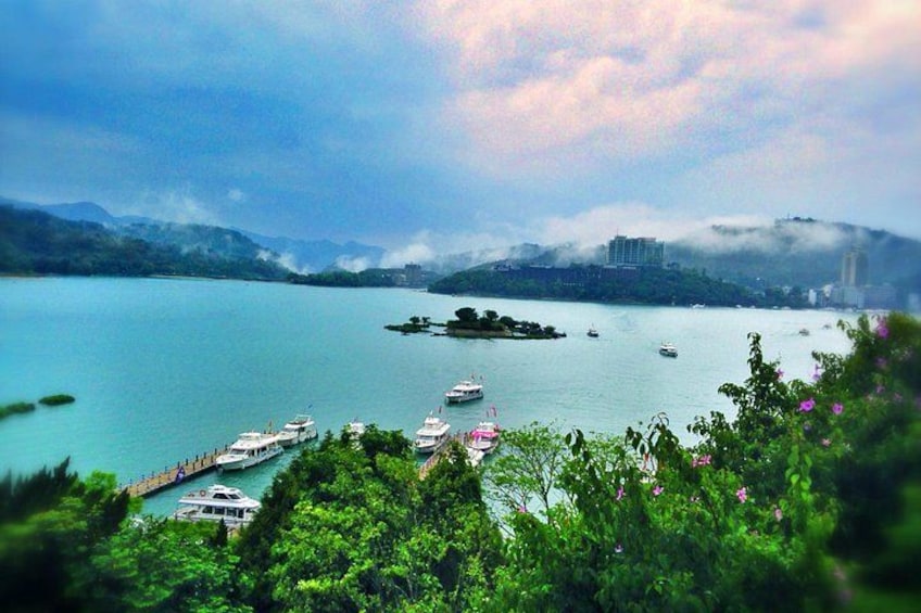 Un lago con barche, un molo e un paesaggio montuoso sullo sfondo. 1
