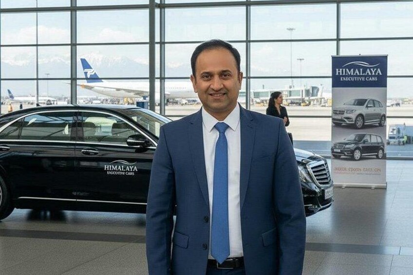 A man in a blue suit standing in front of a black car with 'HIMALAYA EXECUTIVE CARS' signage. 3