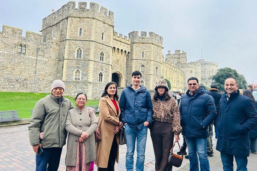 A group of people standing in front of a historic castle. 2