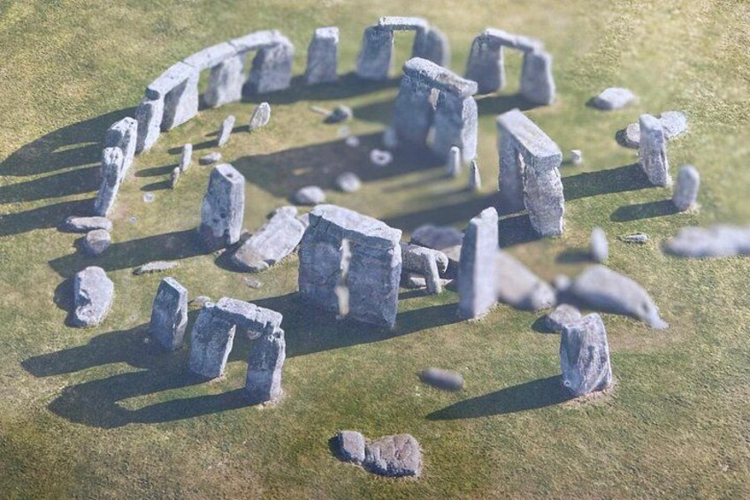 A stone circle with standing stones arranged in a circular pattern on a grassy field. 5