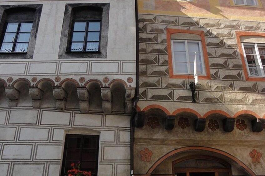 A building with a patterned facade, arched windows, and a door with a flower box. 4