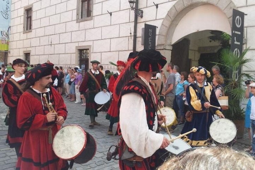 People in historical costumes playing drums in an outdoor setting. 5