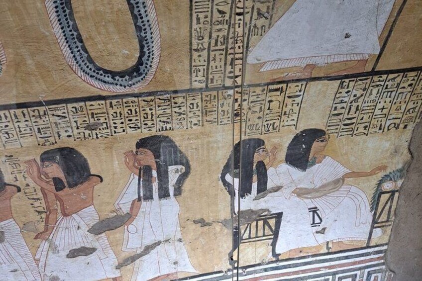 An ancient Egyptian wall with hieroglyphs and a depiction of a family scene. 5