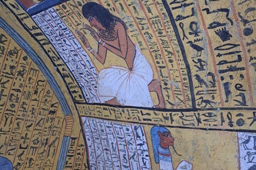 A mural with hieroglyphics and a depiction of a woman in traditional attire. 3