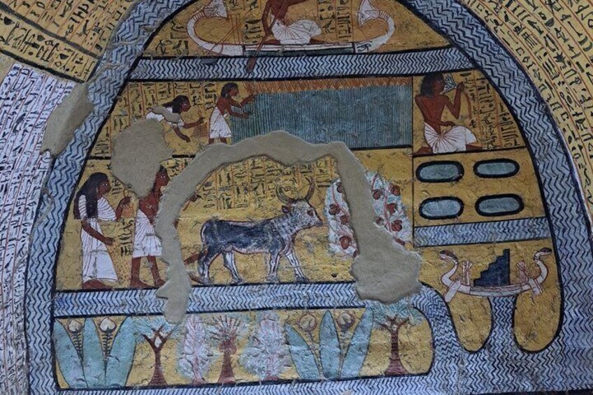 An ancient Egyptian wall with hieroglyphics, a depiction of a cow, and figures in traditional attire. 4