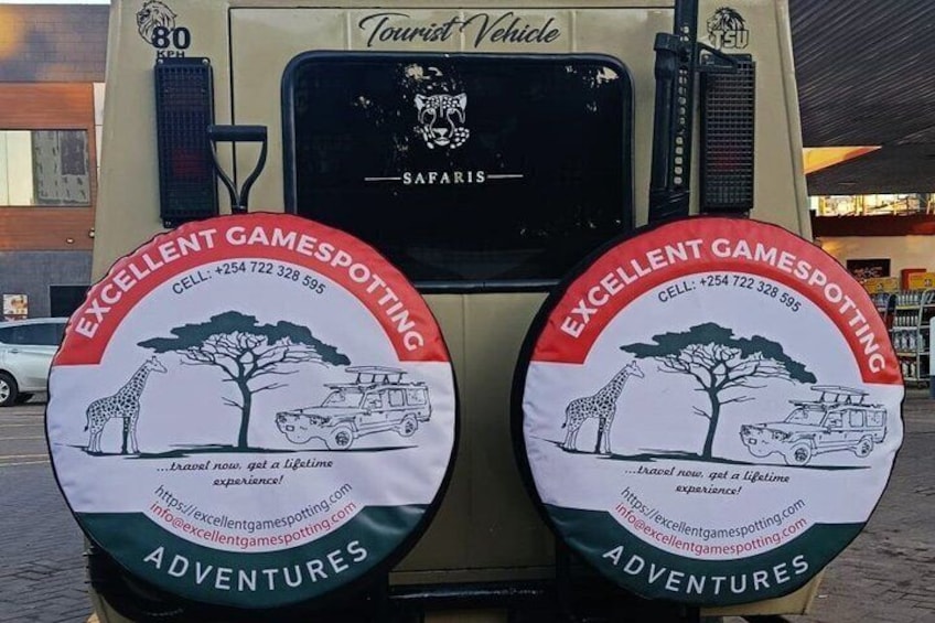 A safari vehicle with two circular stickers advertising Excellent Gamespotting Adventures. 2