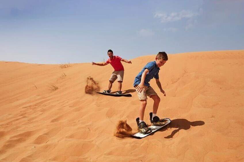 Two people riding a dune buggy on a sandy dune. 4
