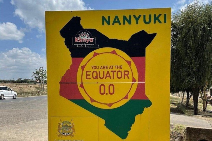 A sign with a map of Kenya and the text 'NANYUKI' and 'YOU ARE AT THE EQUATOR 0.0'. 1