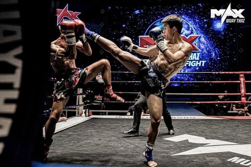 En Muay Thai-kamp i en ring med en stjernelogo og et baggrundsbillede med rumtema. 1