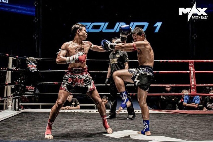 En boksekamp i en ring, med et skilt i baggrunden der viser 'ROUND 1'. 4