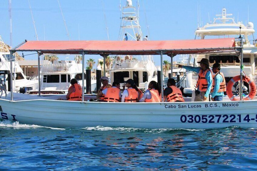 A boat with people wearing life jackets, labeled 'Cabo San Lucas B.C.S., Mexico,' on the water. 5