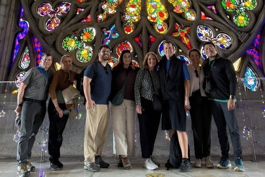 Un grupo de personas frente a un edificio con vidrieras de colores. 1