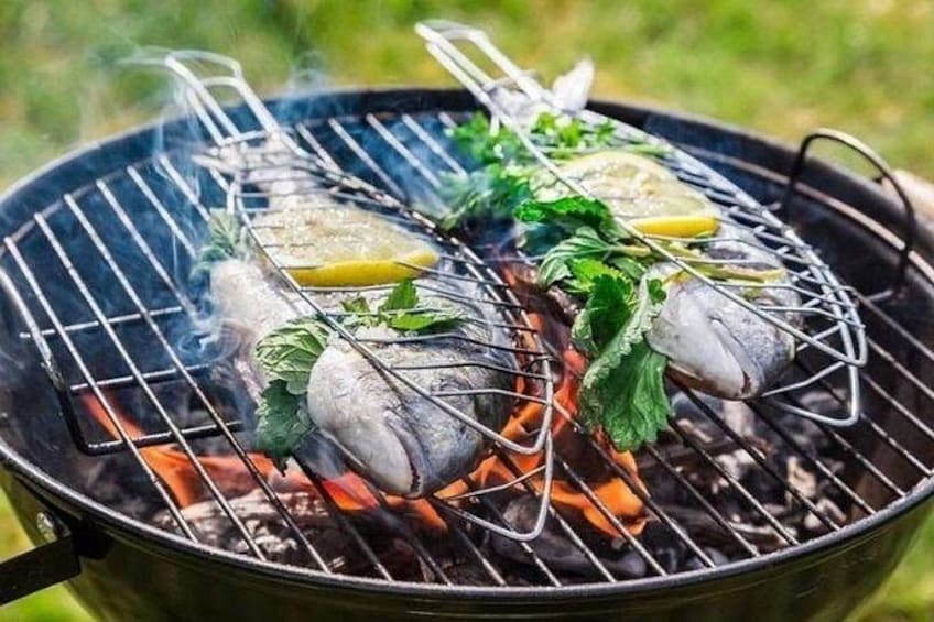 Una parrilla con pescado y rodajas de limón. 5