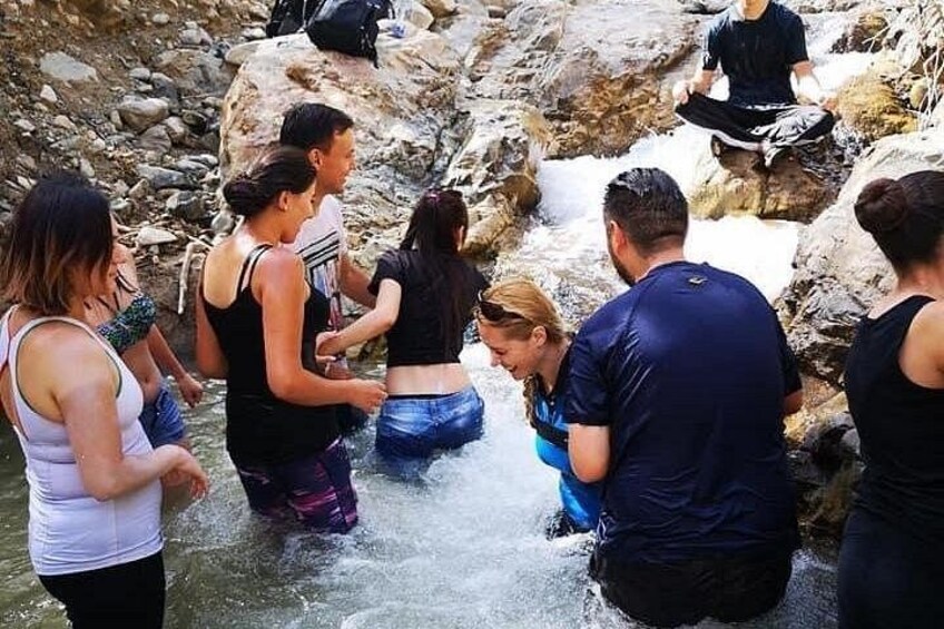 Un grupo de personas de pie en un arroyo pedregoso. 4