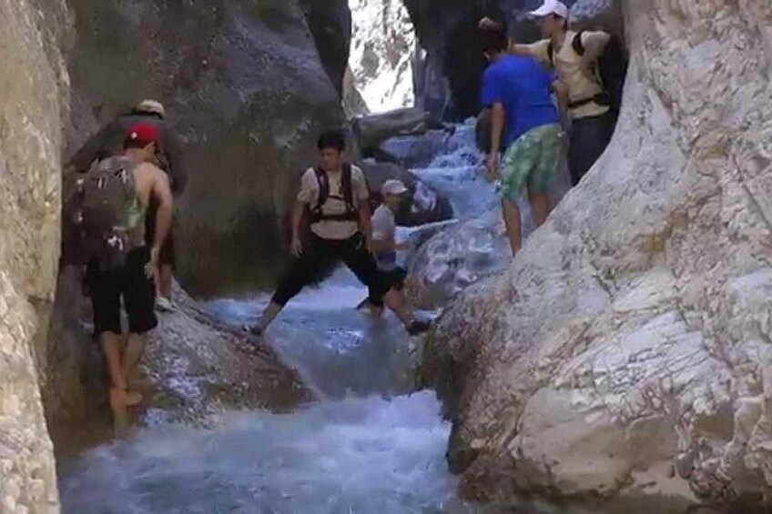 Un grupo de personas recorre un estrecho canal rocoso. 3