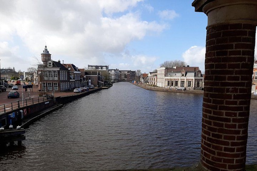 A canal with buildings on both sides, a bridge, and a brick column. 2