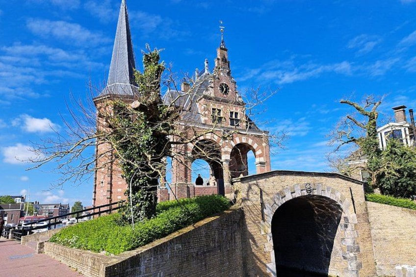 A historic church with a tall spire, a stone bridge, and a clear blue sky. 1