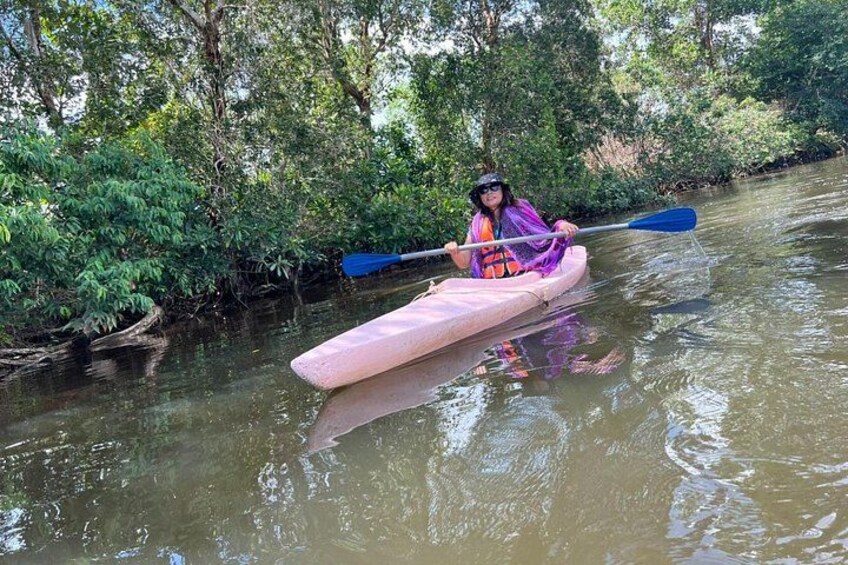 A person kayaking on a river surrounded by dense greenery. 4
