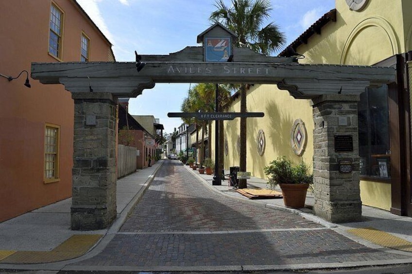 A street with a sign reading 'Aviles Street' and a clear sky. 4
