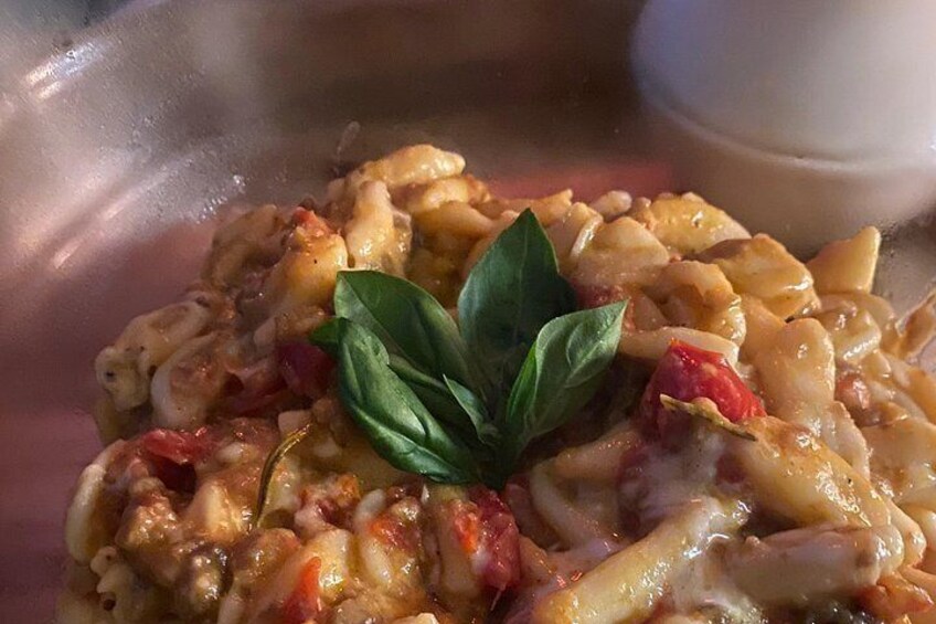 Ein Nahaufnahme eines Pastagerichts mit Basilikum-Garnitur. 5