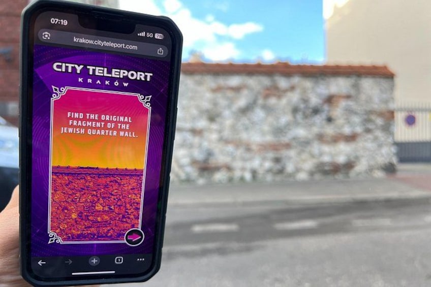A smartphone displaying a city teleport app with a task to find the original fragment of the Jewish Quarter wall. 5