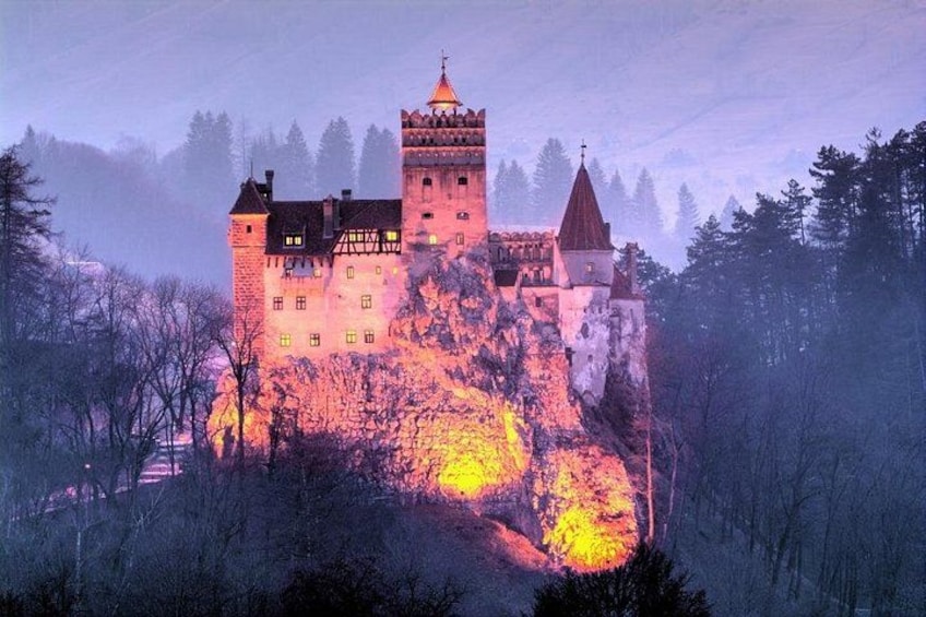 Un château perché sur une colline, avec des fenêtres illuminées et une tour. 1