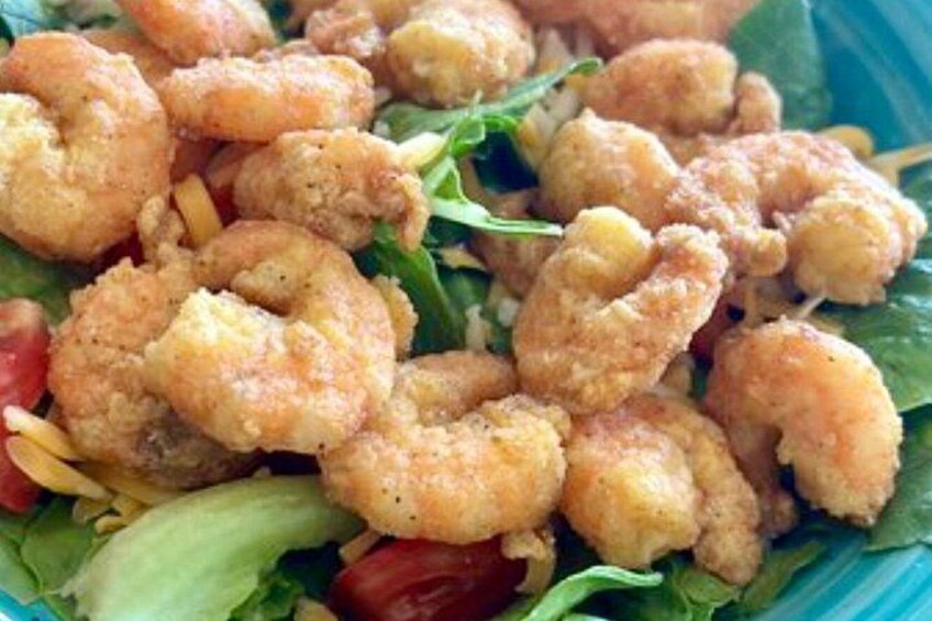 A salad with shrimp, lettuce, and tomatoes. 2