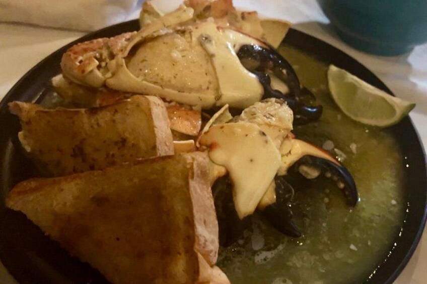 A seafood dish with crab legs and potatoes on a plate. 4