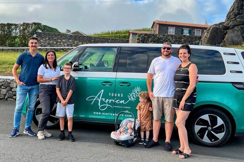 A family posing in front of a green tour bus with the logo 'Tours Azorico'. 3