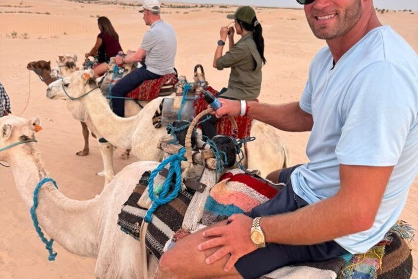 A person riding a camel in a desert. 1