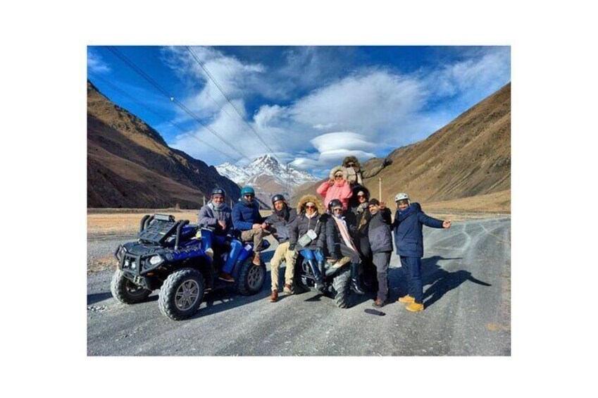 A group of people on a road with a mountainous landscape in the background. 4