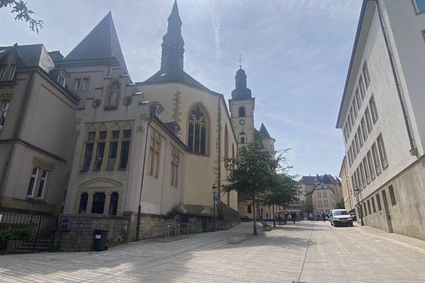 A street with buildings, a church, and a clear sky. 2