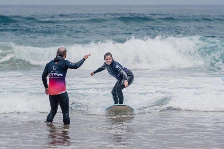 Two people surfing on a wave with a calm sea in the background. 5