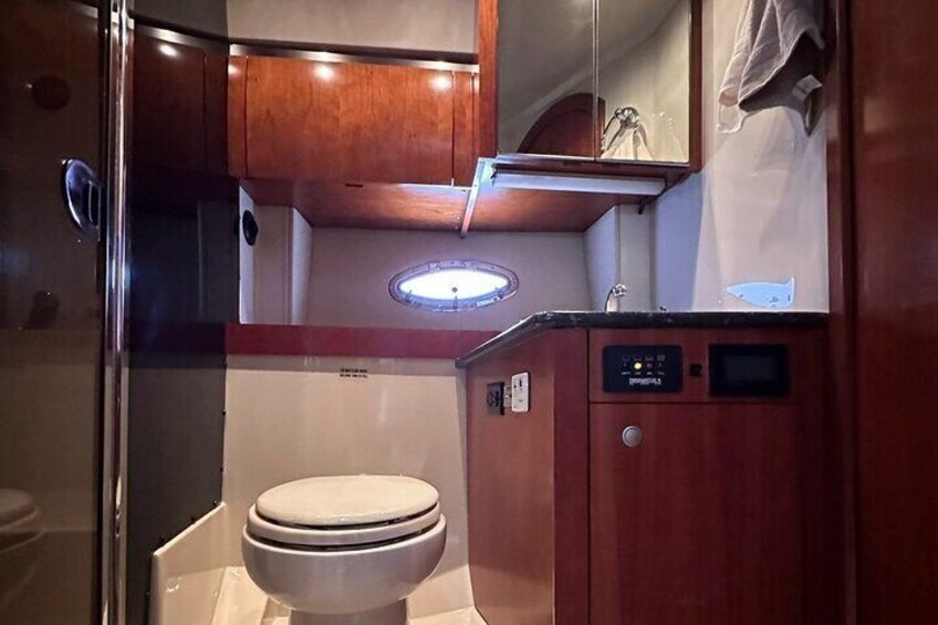 Un bagno compatto con il water, mobili in legno e un piccolo lavandino. 3
