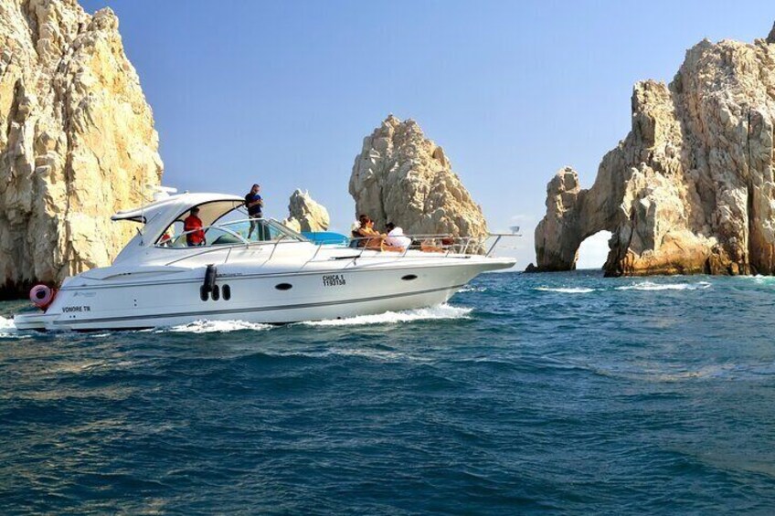 Uno yacht bianco con passeggeri che naviga vicino a scogliere rocciose. 1