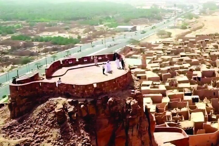 A historical fort with a stage, surrounded by traditional mud-brick buildings. 4