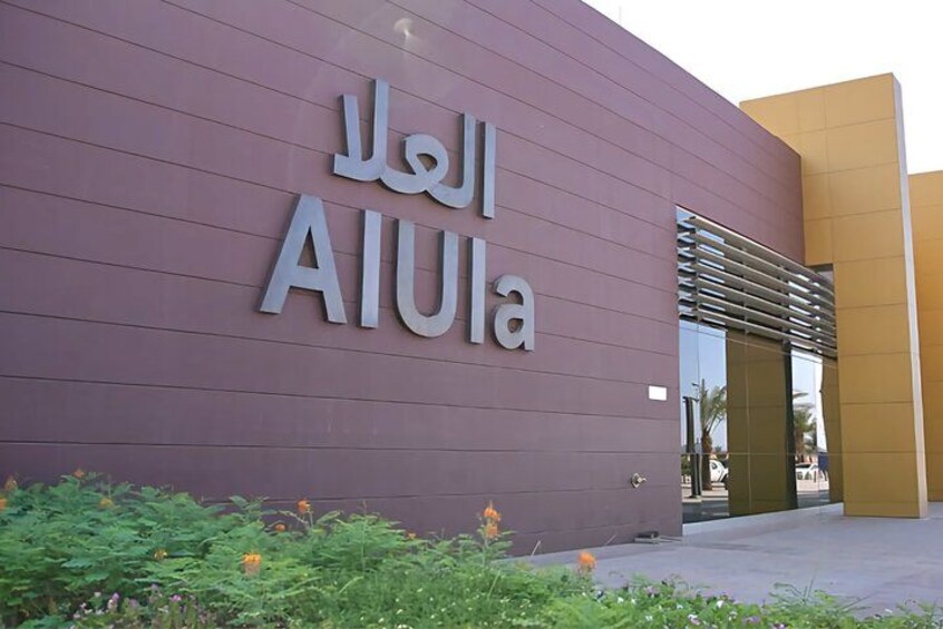 A building with a sign that reads 'AIUla' in Arabic. 4
