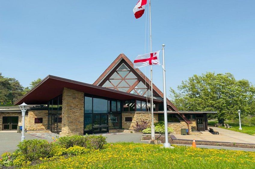 A modern building with a glass facade, a stone base, and a triangular roof. 5
