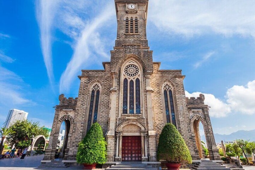 Una chiesa storica con una torre dell'orologio, finestre ad arco e una porta rossa. 5