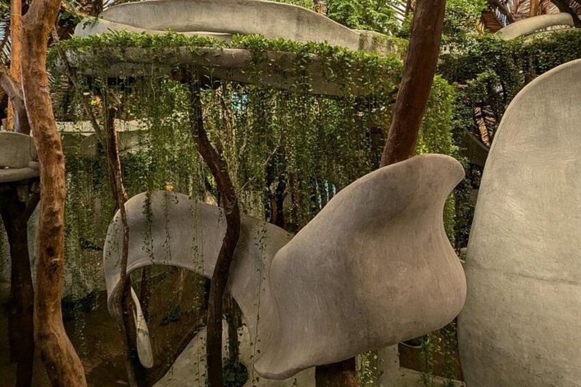 Un jardín con esculturas abstractas y abundante vegetación. 4