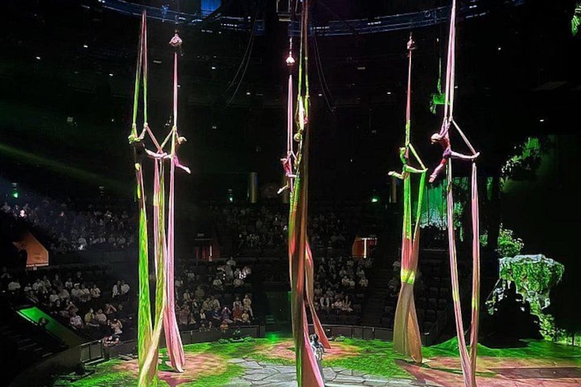 Akrobatinnen in rosa und grünen Tüchern schweben an der Theaterdecke. 3