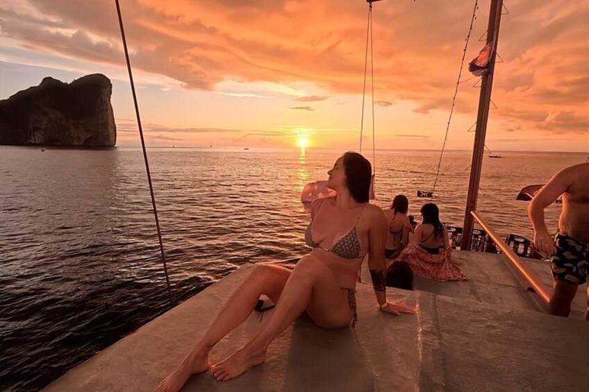 Tramonto sull'oceano con persone che si rilassano su una barca. 3