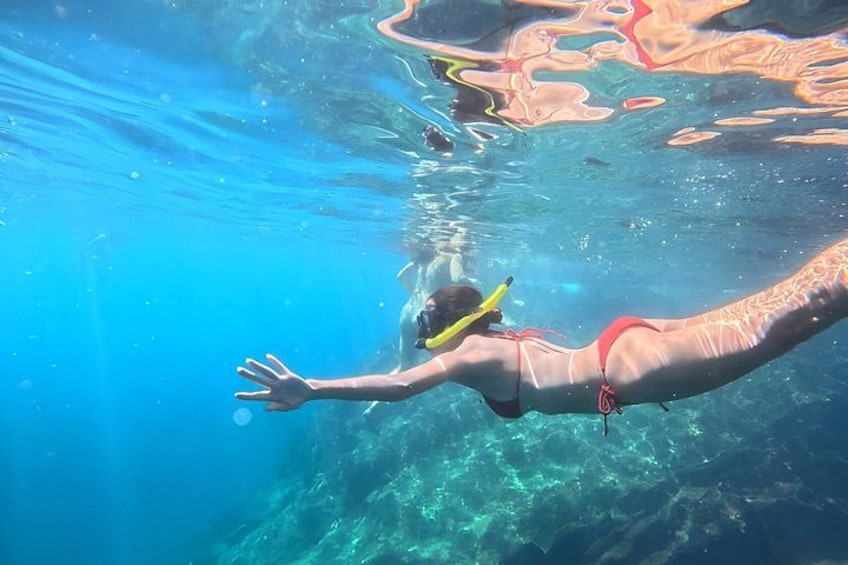 Una persona che nuota sott'acqua con maschera e pinne. 5
