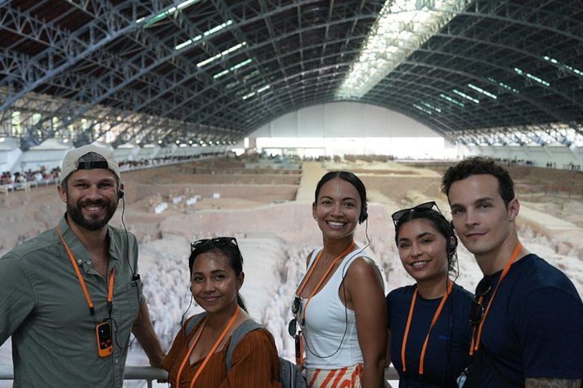 A group of people in an indoor archaeological site with a large open space and a high ceiling. 2