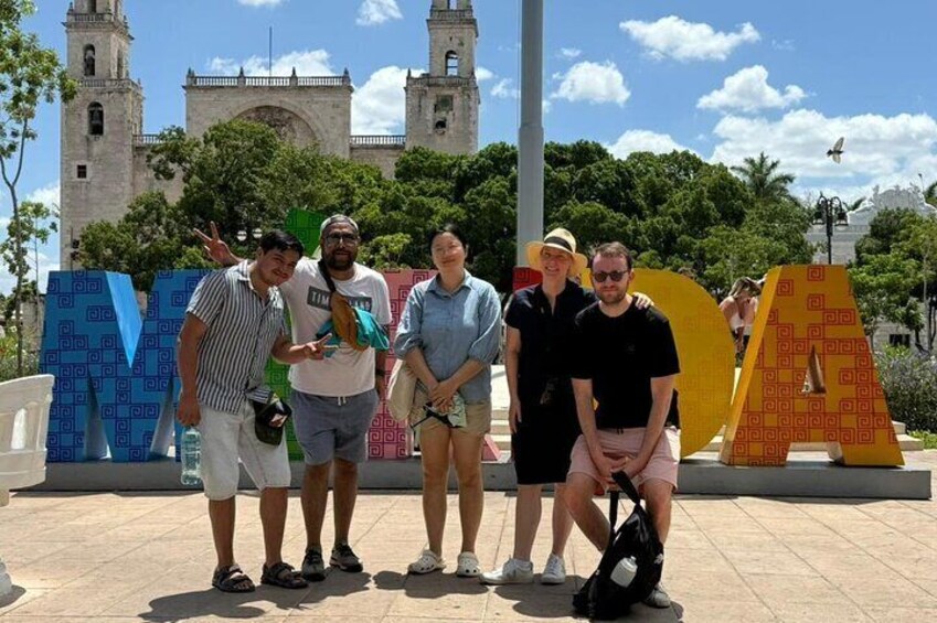 Un groupe de personnes posant devant une grande sculpture colorée aux motifs géométriques. 5